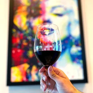 a hand holding a glass of red wine