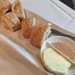Crusty rolls with 2 butters: shallot, chives, and parsley (savory) and cinnamon (sweet).