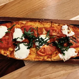 a pizza with tomatoes, mozzarella and basil