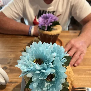 a man sitting at a table with a flower in a pot