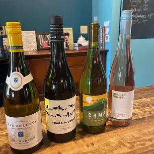 three bottles of wine on a wooden table