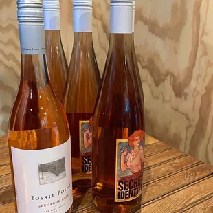 three bottles of wine on a wooden table