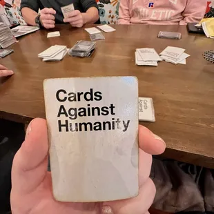 a person holding a card against humanity