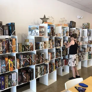 a woman standing in front of a wall of books