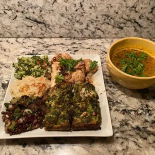 Tabouli quinoa, cauliflower in a tahini sauce, babaghanoush, black lentil salad, broccoli latke, and split pea soup