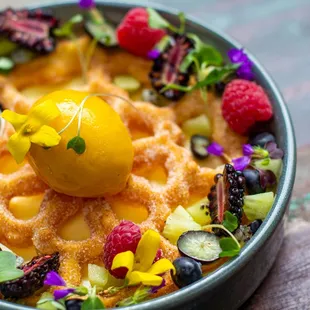 a bowl of waffles with fruit on top