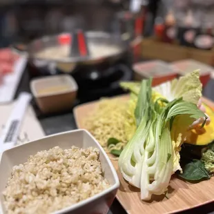 a bowl of rice, lettuce, and a bowl of broccoli