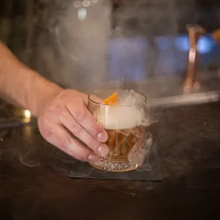 a person holding a glass of alcohol