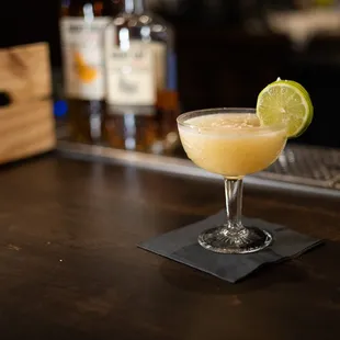 a cocktail with a lime slice on the rim