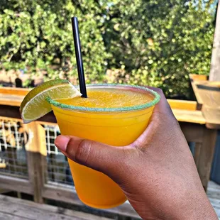 a hand holding a glass of orange juice