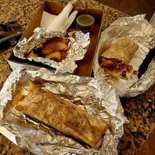 two burritos wrapped in aluminum foil