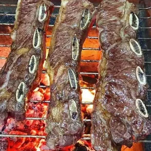 steaks cooking on a grill