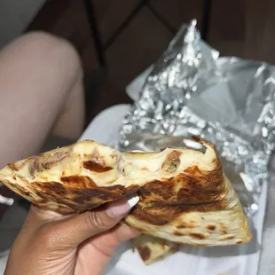 a person holding a piece of food