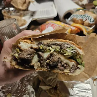 a person holding a sandwich