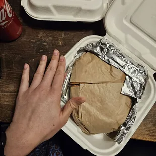 a person grabbing a piece of food out of a container