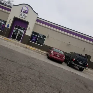 two cars parked in front of a taco bell store