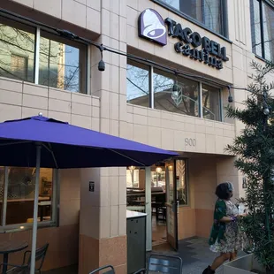 a woman walking past a taco bell restaurant
