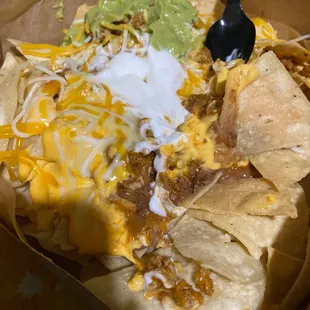 a plate of nachos with cheese and guacamole
