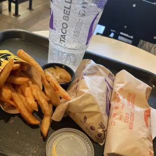 Double stacked taco and nachos fries and burrito beef and drink soda