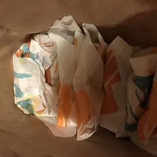 Greasy wet tacos crammed into a paper sack these are party packs and they are to be in boxes