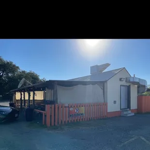 a taco stand with a car parked in front of it