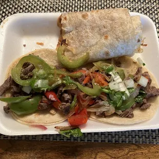 Carne asada tacos fajita style with a shared half of a bean and cheese burrito.