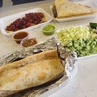 Burritos de al pastor, salad bar options, salsas, 2 tacos de al pastor, quesadilla de asada.