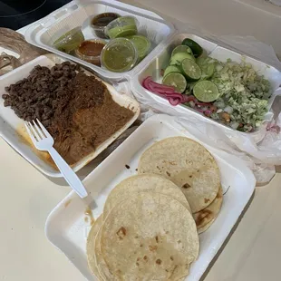 Carne asada/barbacoa plate with beans and corn tortillas and toppings from the salsa/toppings bar.
