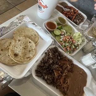 Carne asada tacos with beans and corn tortillas with taco toppings
