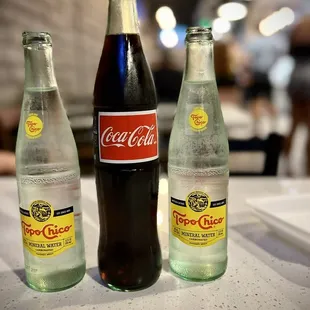 three bottles of coca cola on a table