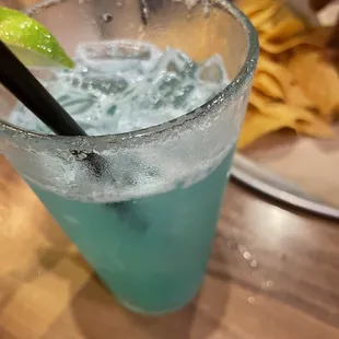 a blue drink with a lime slice