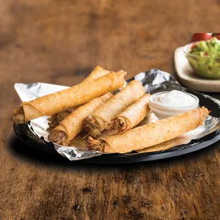 a plate of tacos and a bowl of guacamole