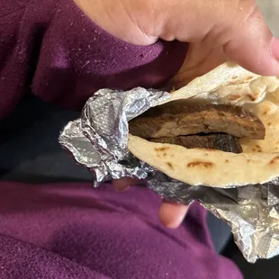 a hand holding a burrito