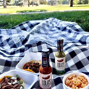 a picnic blanket with food and drinks