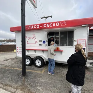 a woman ordering food from a food truck
