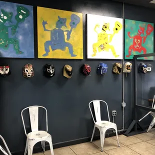 Waiting area featuring masks and wall artwork.