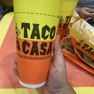 a hand holding a cup of taco casa
