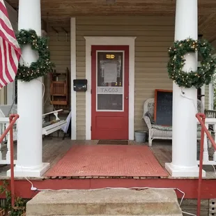 the front porch of a home decorated for christmas