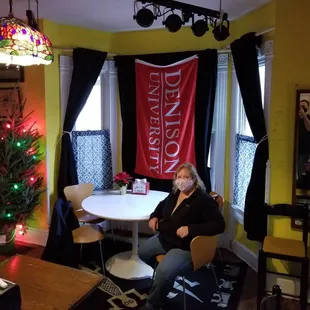 a woman sitting at a table in a brightly lit room