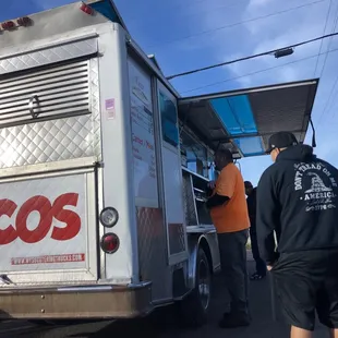 two men loading a taco truck