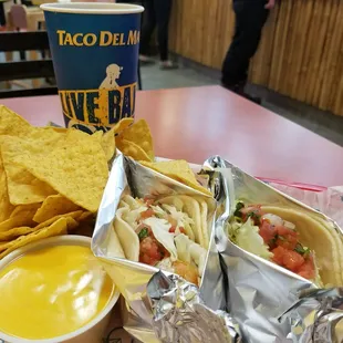 Fish and shrimp taco with a combo meal chips and queso