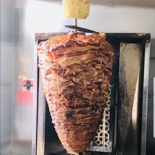 the meat being cooked on a skewer