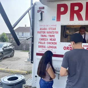 two people ordering food from a food truck