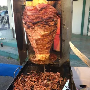 the meat being cooked on a skewer