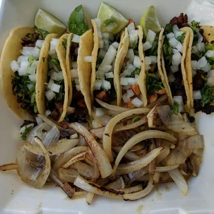 a variety of tacos in a styrofoam container