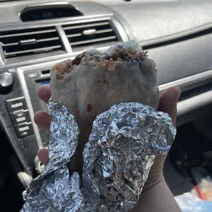 a hand holding a burrito