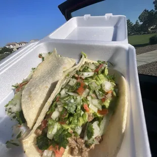 two tacos in a styrofoam container