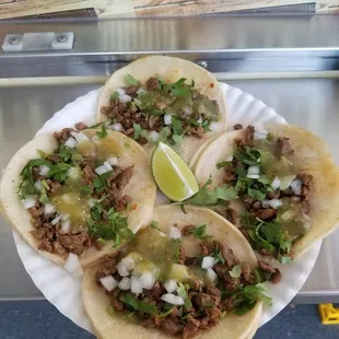three tacos on a paper plate