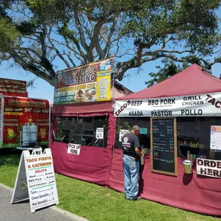 a man standing in front of a taco stand