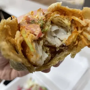 a hand holding a half eaten sandwich